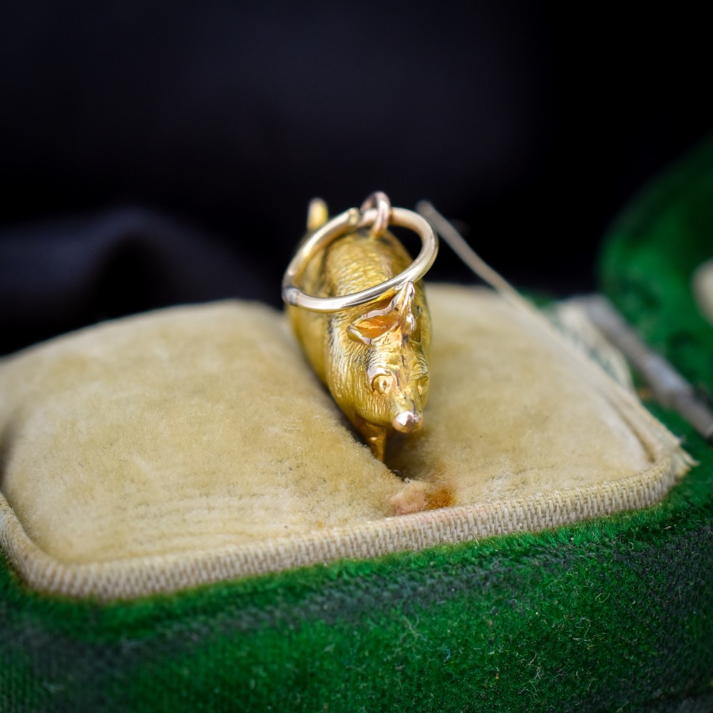 An Edwardian 9ct yellow gold pig charm featuring a textured three-dimensional body and an attached suspension ring. View II