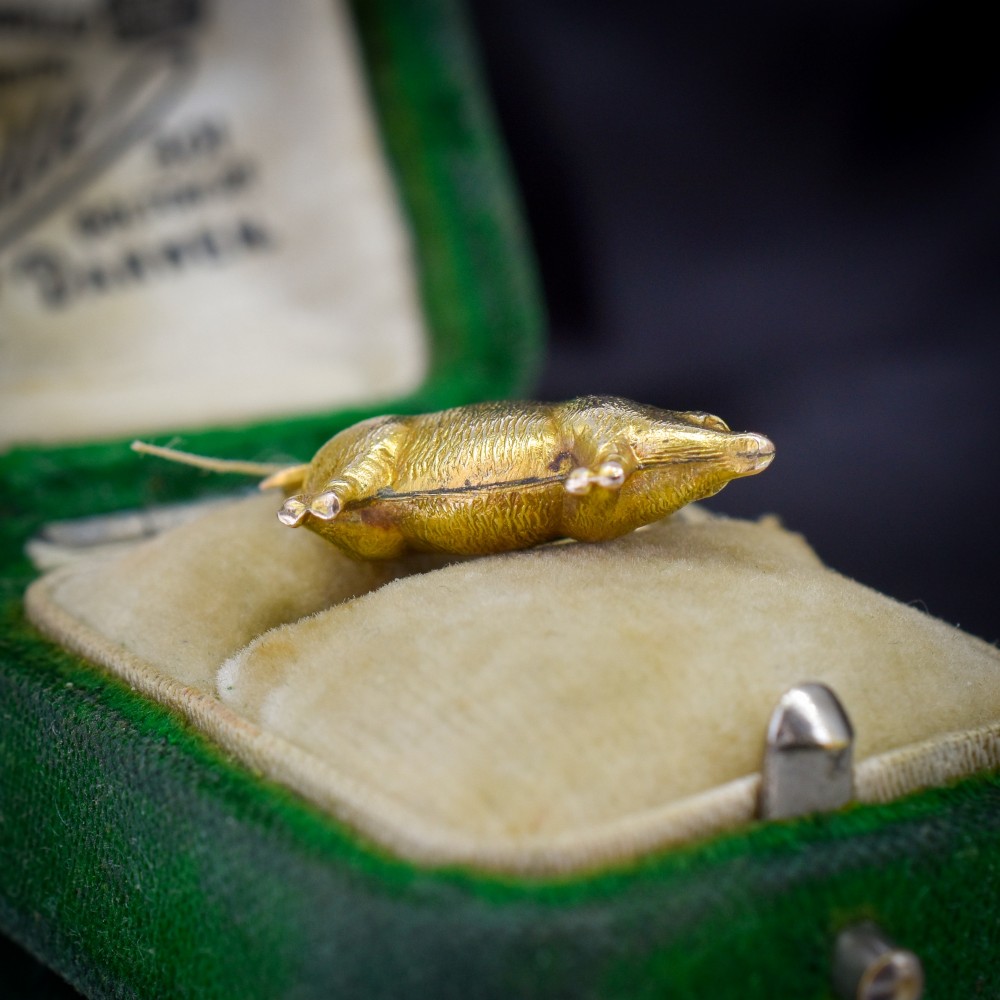 An Edwardian 9ct yellow gold pig charm featuring a textured three-dimensional body and an attached suspension ring. View IV