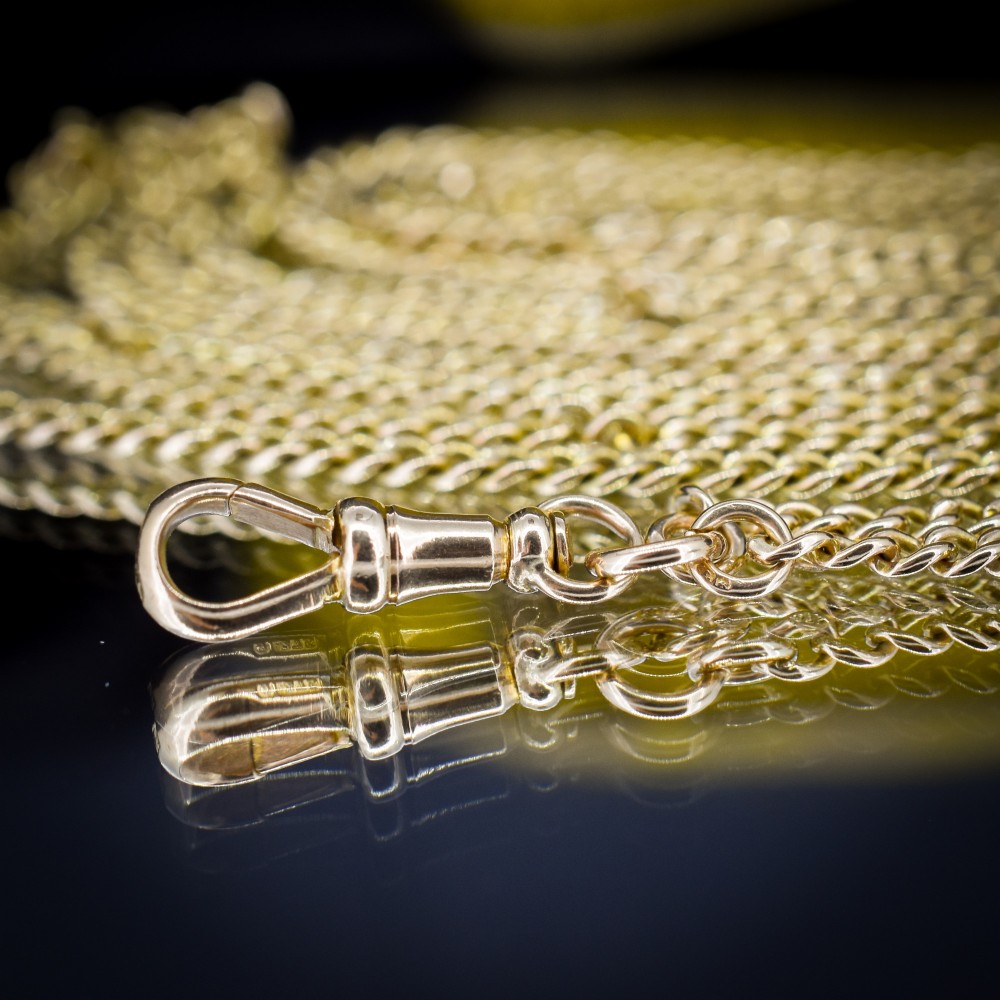 An antique 9ct yellow gold curb link guard chain layered in multiple loops with a dog clip fastener on a black bust. View VI