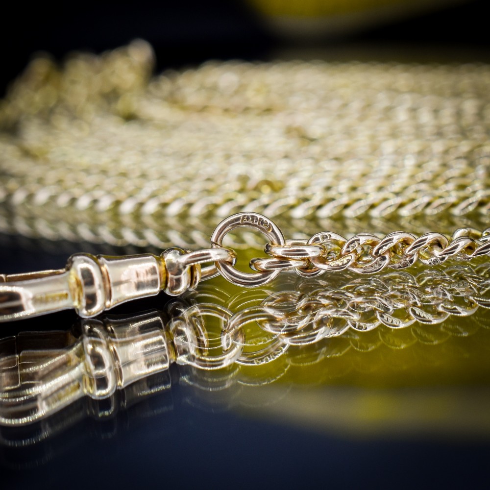 An antique 9ct yellow gold curb link guard chain layered in multiple loops with a dog clip fastener on a black bust. View VII
