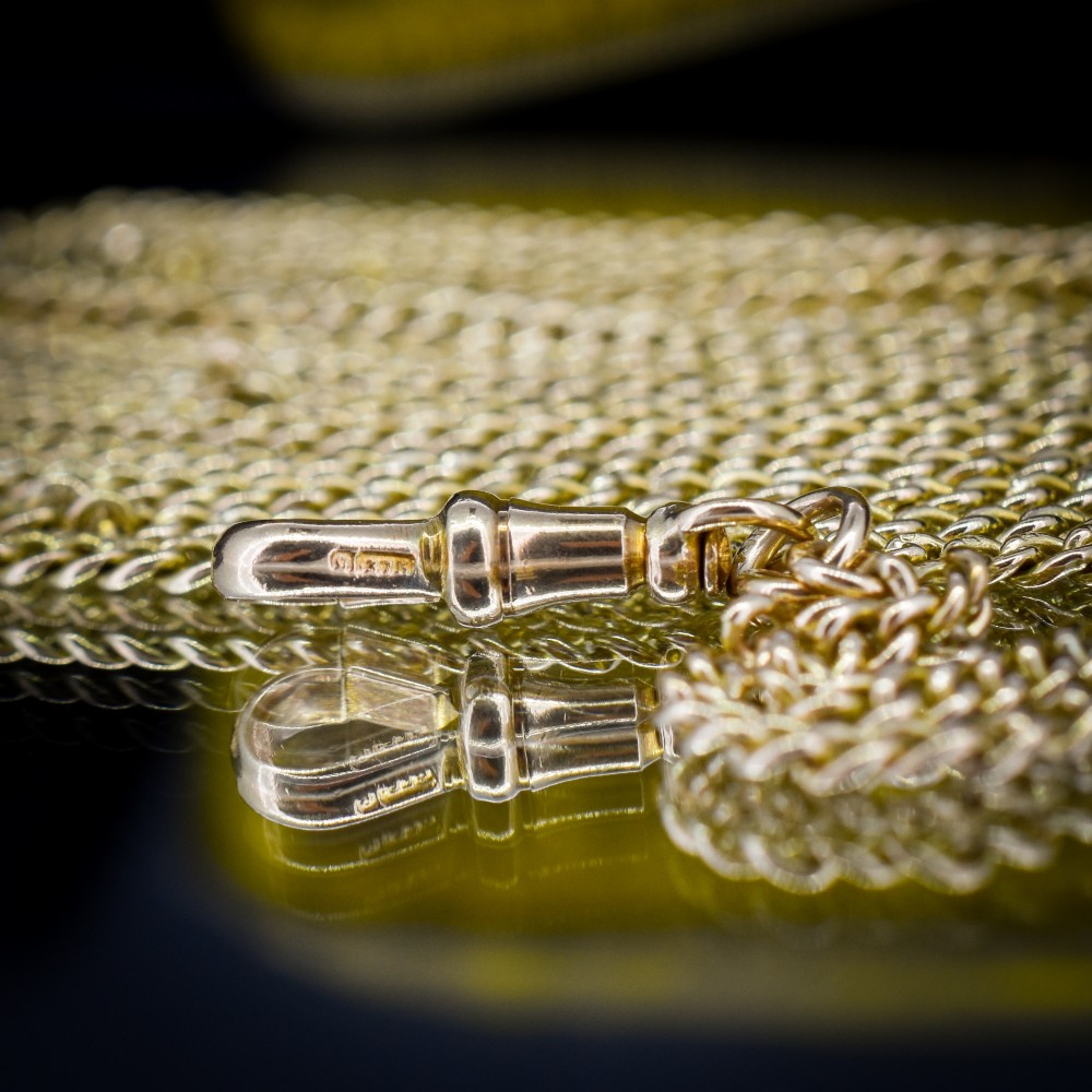 An antique 9ct yellow gold curb link guard chain layered in multiple loops with a dog clip fastener on a black bust. View VIII
