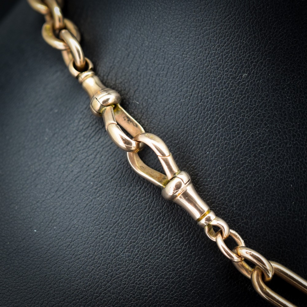 An Edwardian 9ct gold trombone link chain necklace with a central T-bar drop and dog clip clasp. View III
