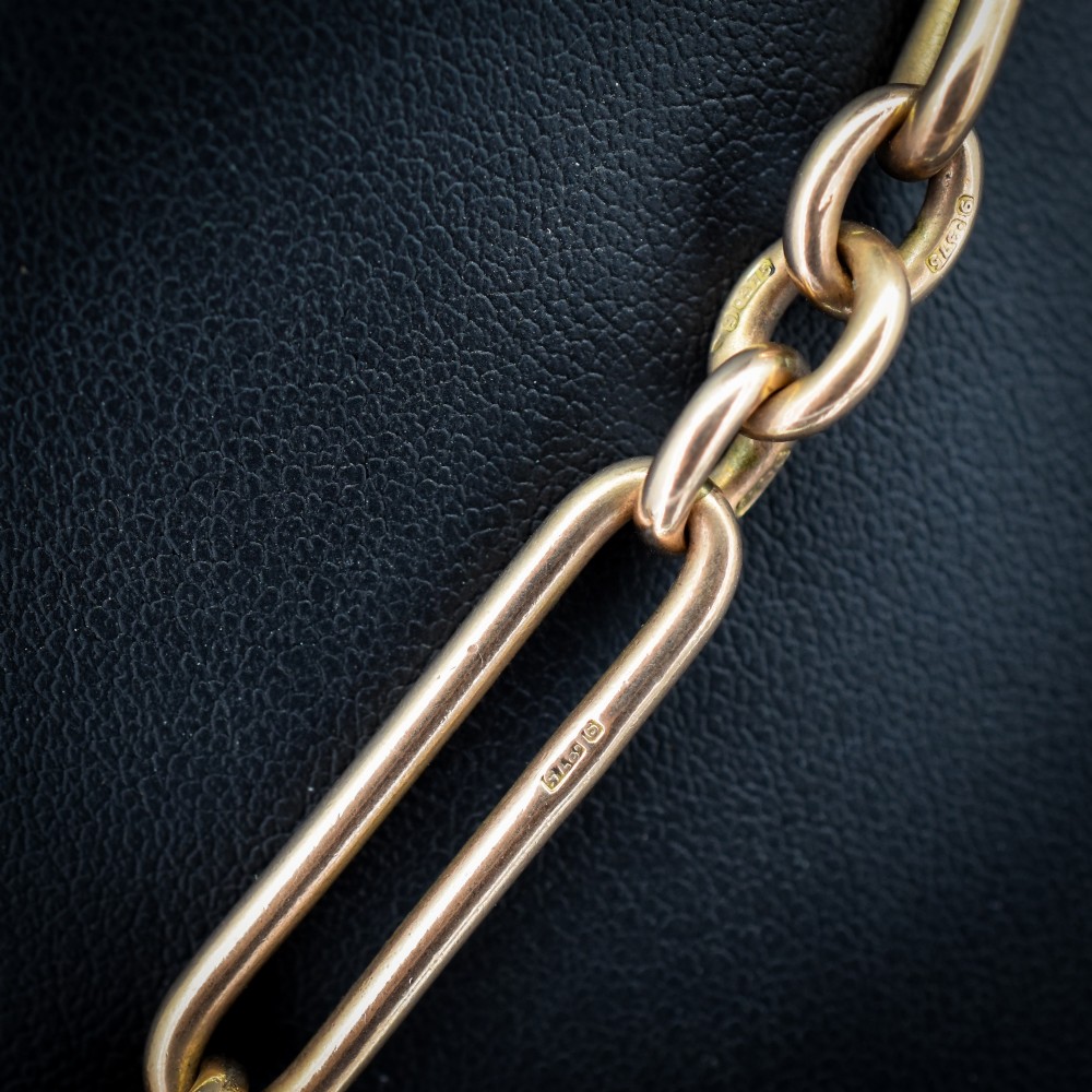 An Edwardian 9ct gold trombone link chain necklace with a central T-bar drop and dog clip clasp. View IV