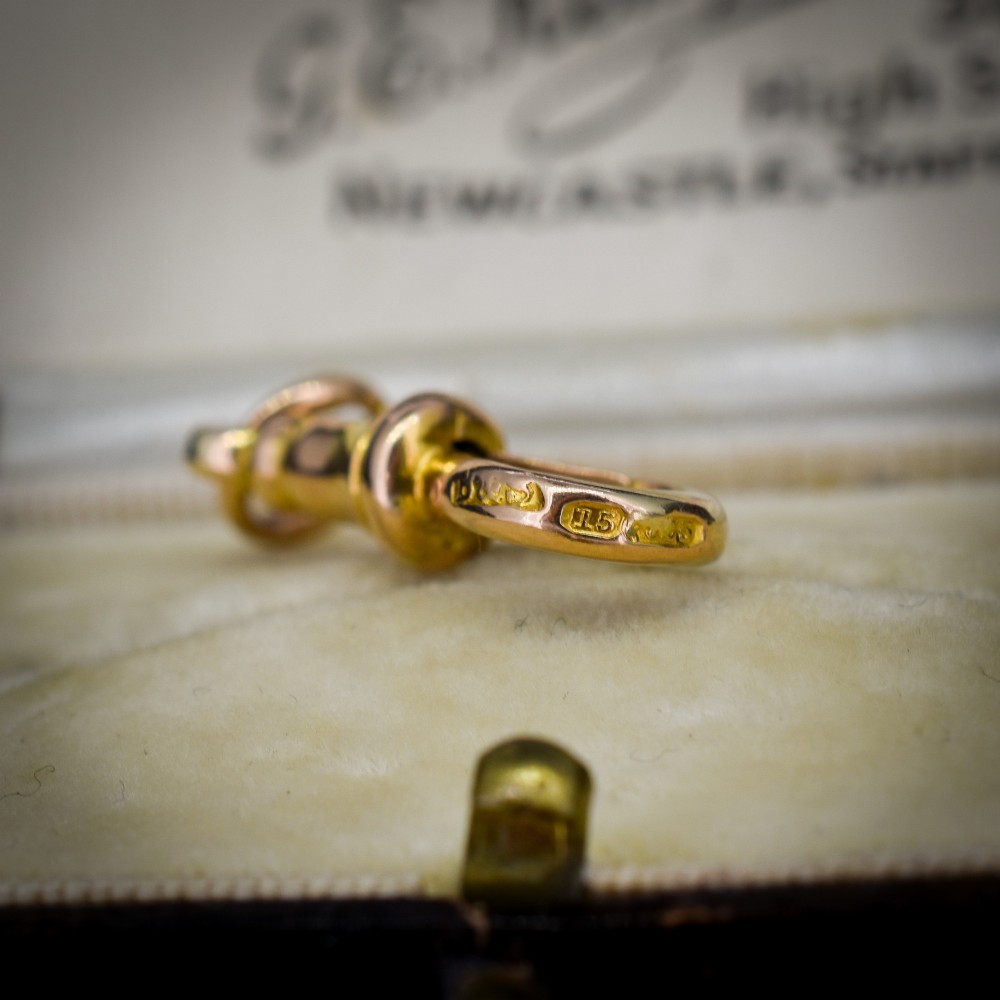 An antique 15ct yellow gold dog clip swivel clasp resting inside a silk-lined presentation box. View III