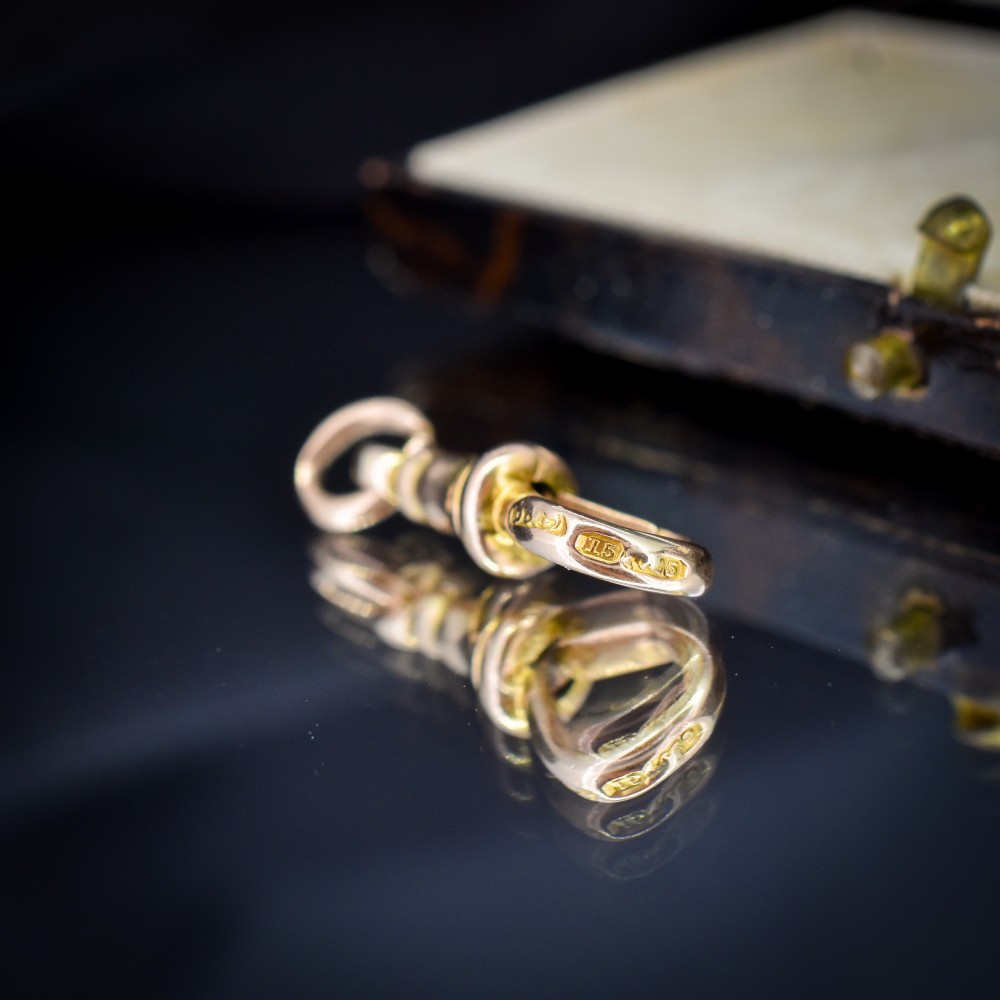 An antique 15ct yellow gold dog clip swivel clasp resting inside a silk-lined presentation box. View VIII
