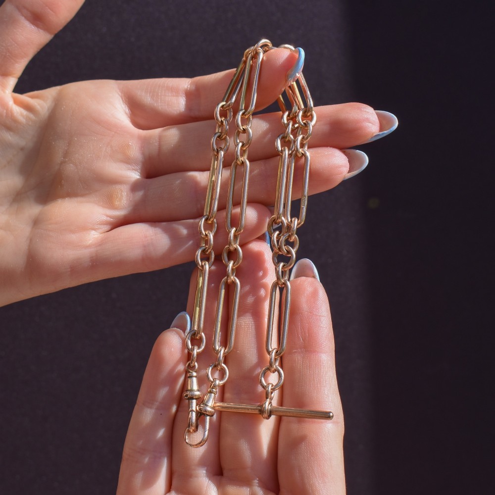 A 9ct yellow gold Albert chain necklace featuring alternating trombone links and a central T-bar pendant drop. View IX
