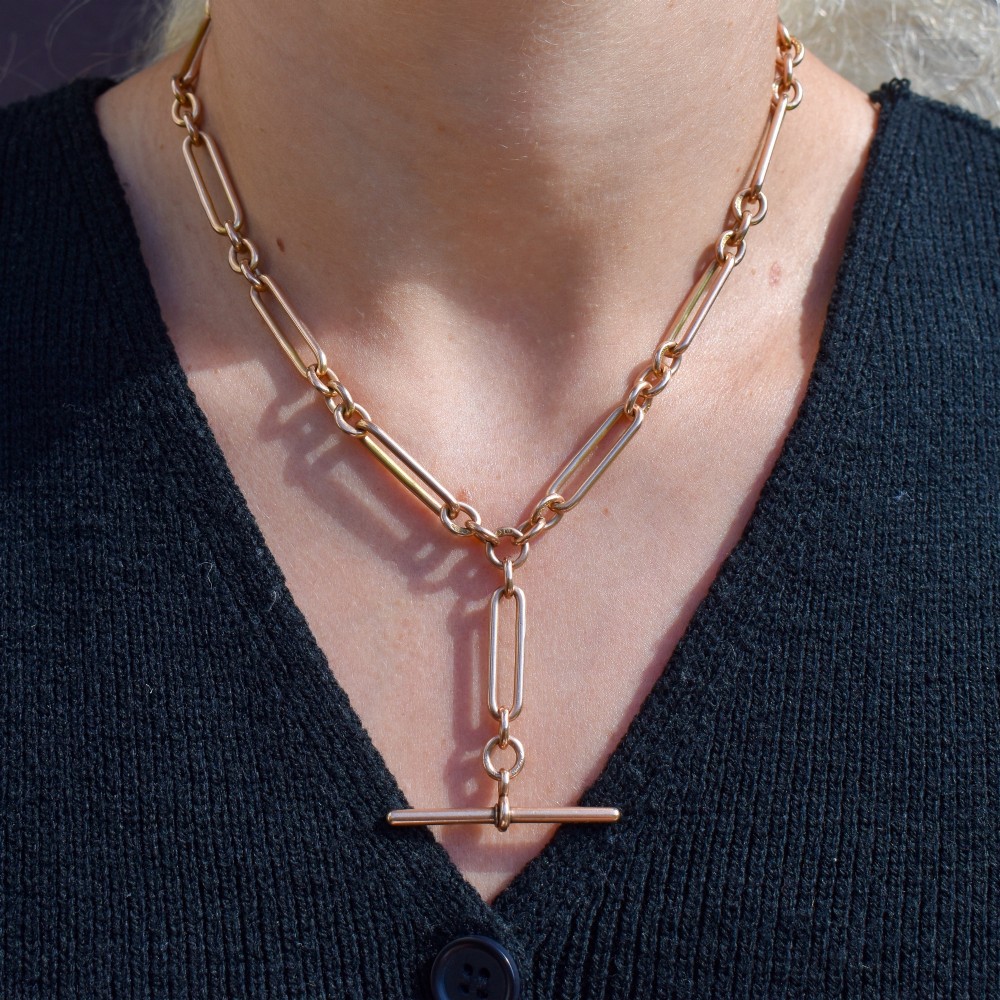 A 9ct yellow gold Albert chain necklace featuring alternating trombone links and a central T-bar pendant drop. View X