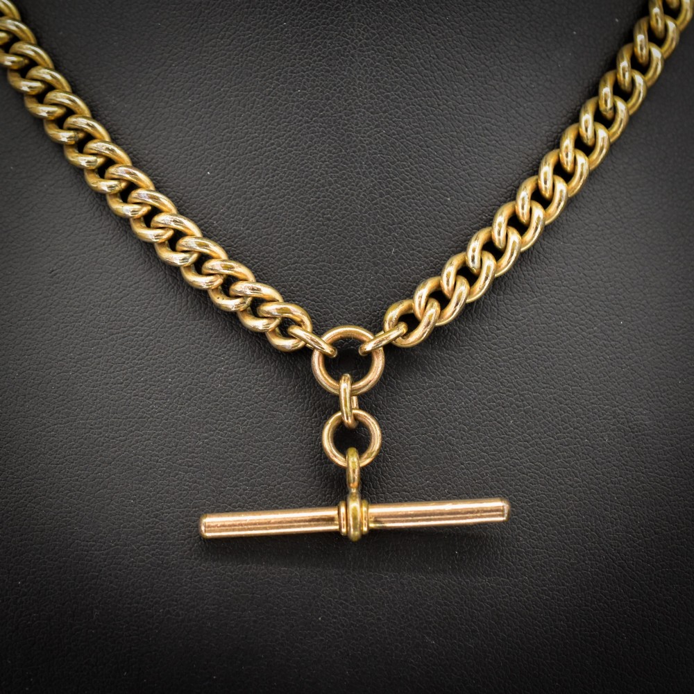 An antique rolled gold curb link watch chain featuring a central T-bar dropper and double dog clip fasteners. View III