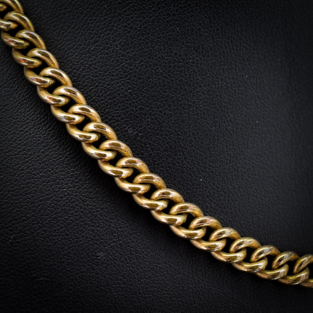 An antique rolled gold curb link watch chain featuring a central T-bar dropper and double dog clip fasteners. View VI