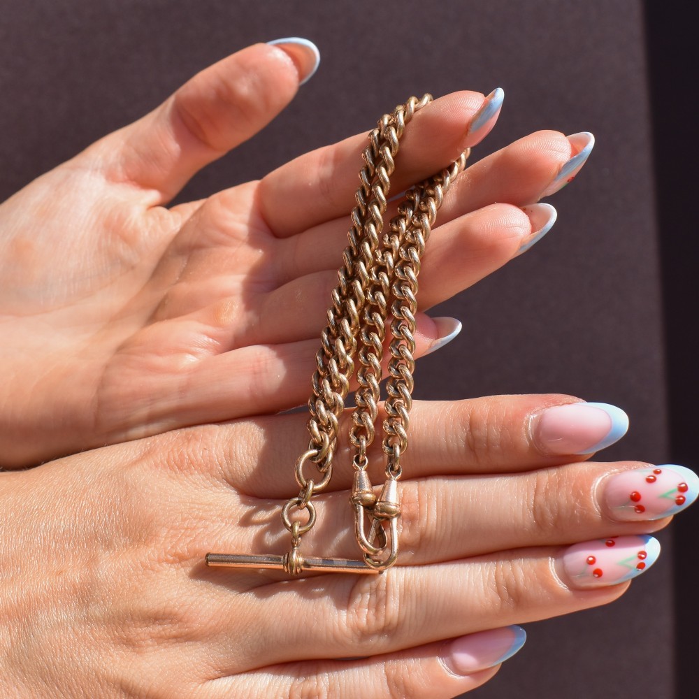 An antique rolled gold curb link watch chain featuring a central T-bar dropper and double dog clip fasteners. View IX