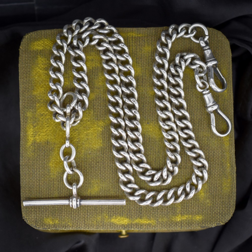 An antique sterling silver Albert watch chain featuring heavy curb links, a central T-bar drop, and two swivel dog clip clasps.