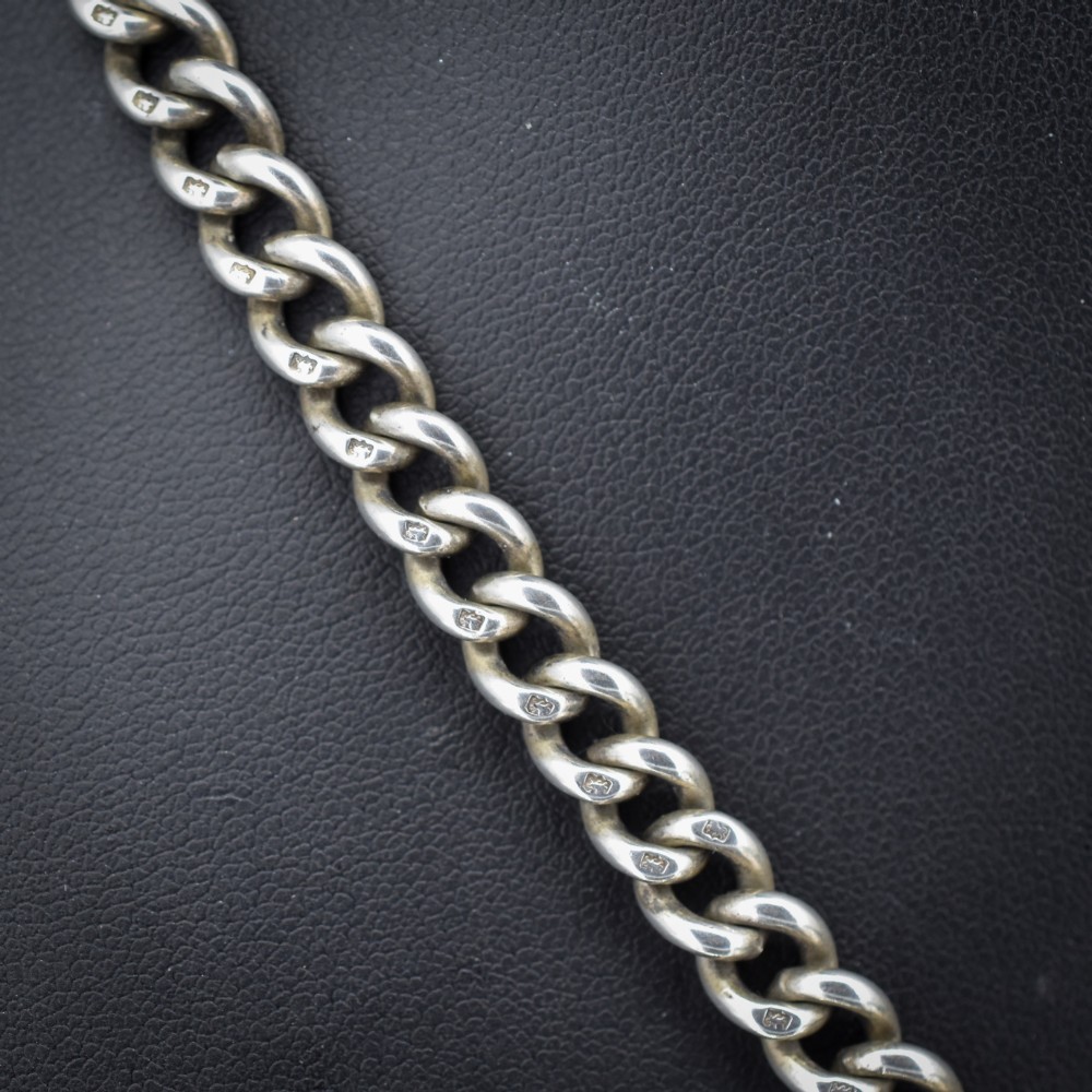 An antique sterling silver Albert watch chain featuring heavy curb links, a central T-bar drop, and two swivel dog clip clasps. View IV