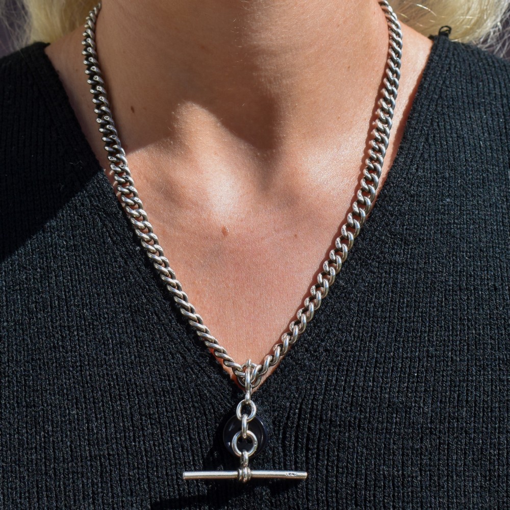 An antique sterling silver Albert watch chain featuring heavy curb links, a central T-bar drop, and two swivel dog clip clasps. View IX
