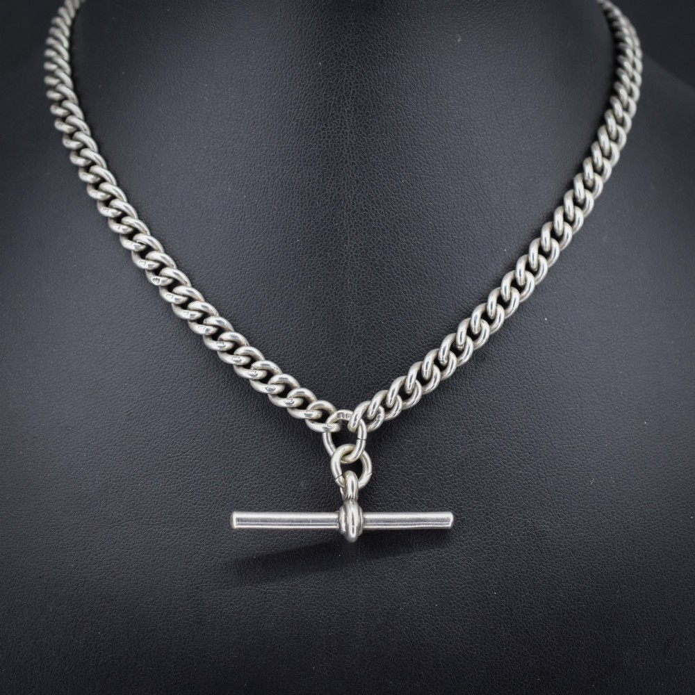 An antique sterling silver uniform curb link Albert watch chain configured as a necklace with a suspended central T-bar.