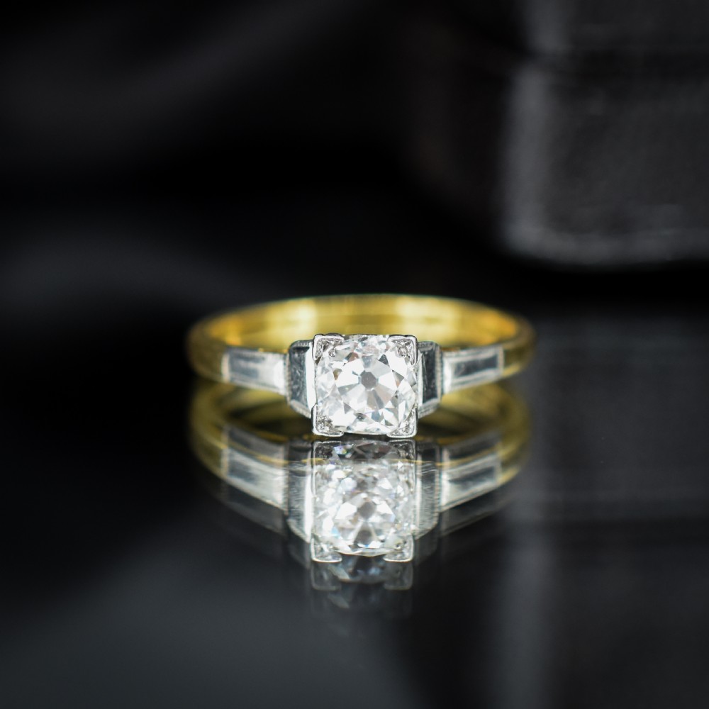 An Art Deco engagement ring featuring a square-set central old cut diamond on an 18ct yellow gold band with white metal stepped shoulders. View III