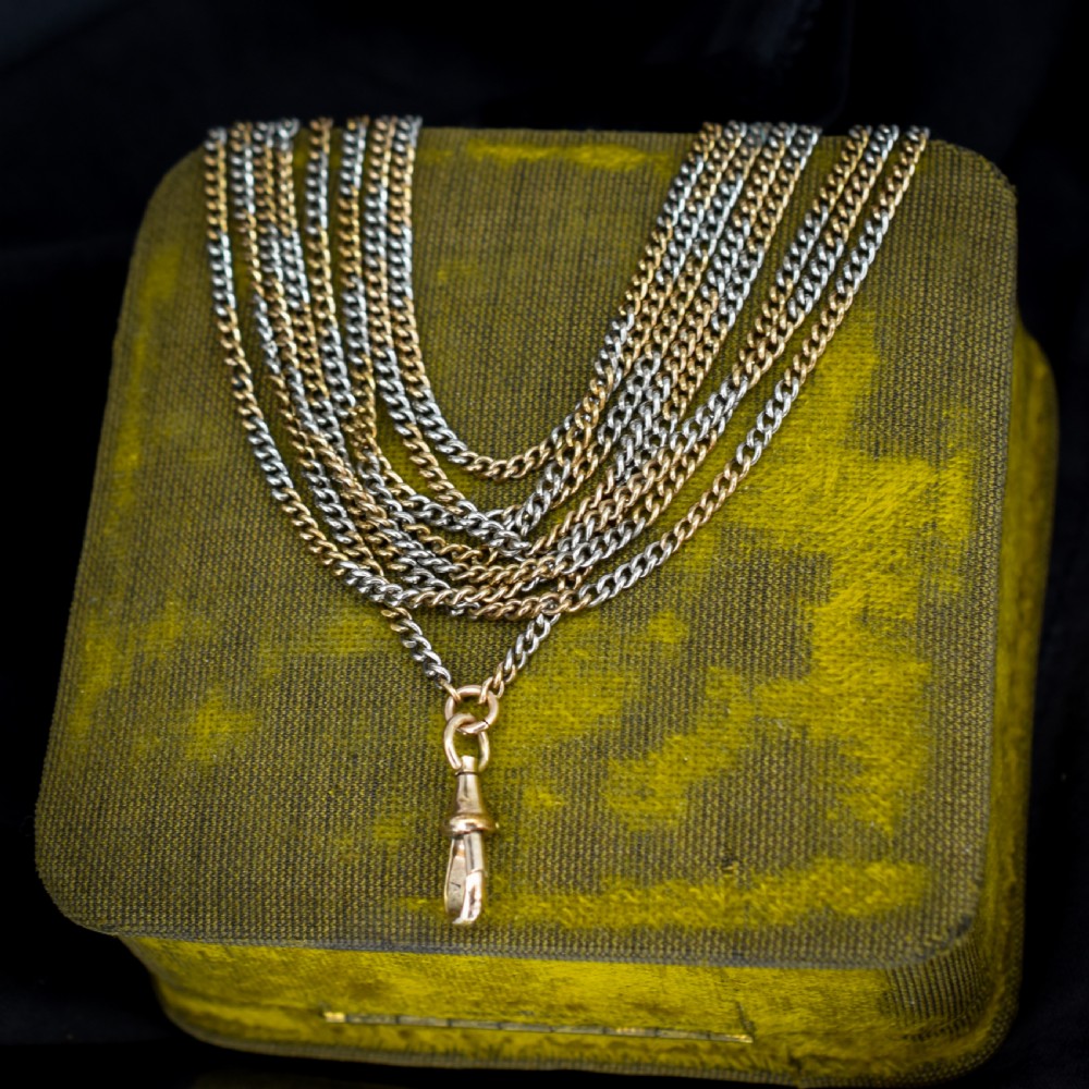 An antique multi-tone metal curb guard chain wrapped in multiple loops with an attached dog clip clasp.