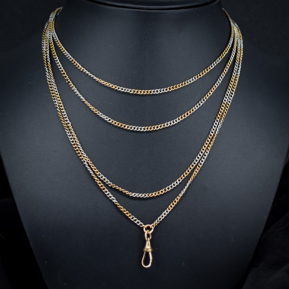 An antique multi-tone metal curb guard chain wrapped in multiple loops with an attached dog clip clasp. View II