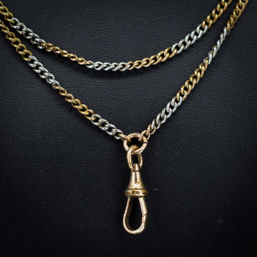An antique multi-tone metal curb guard chain wrapped in multiple loops with an attached dog clip clasp. View III