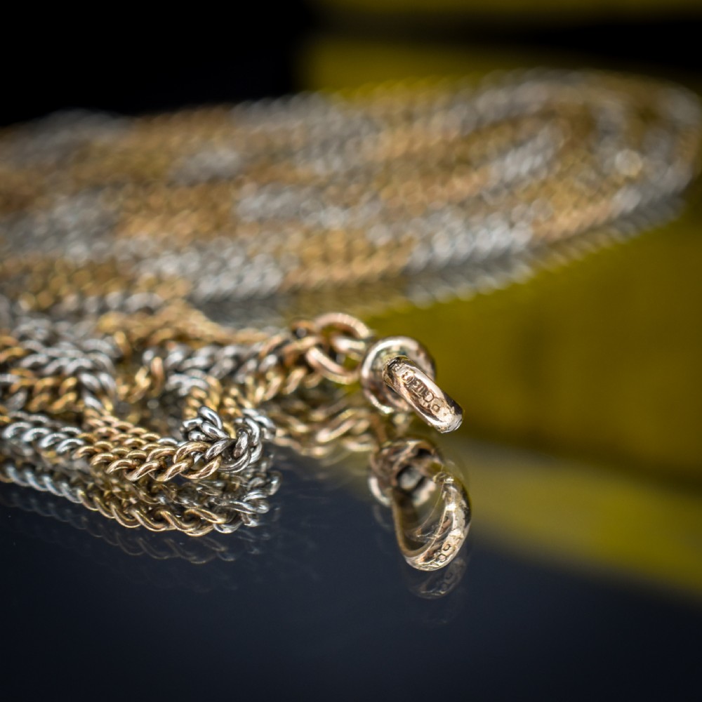 An antique multi-tone metal curb guard chain wrapped in multiple loops with an attached dog clip clasp. View VII