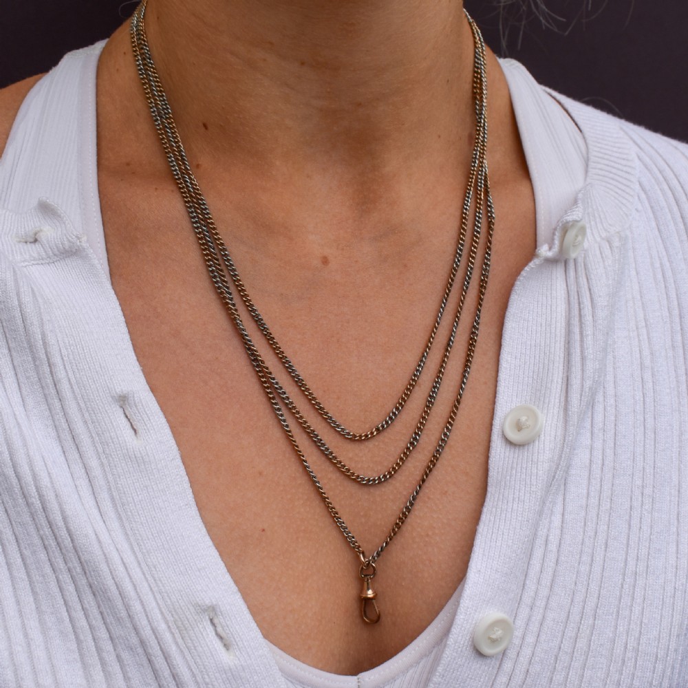 An antique multi-tone metal curb guard chain wrapped in multiple loops with an attached dog clip clasp. View IX