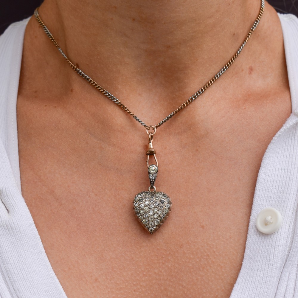 A heart-shaped sterling silver pendant paved with hand-cut clear glass paste stones featuring an ornate bail. View II