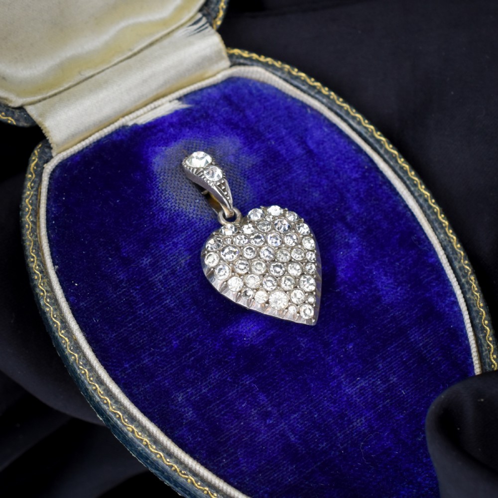 A heart-shaped sterling silver pendant paved with hand-cut clear glass paste stones featuring an ornate bail. View X