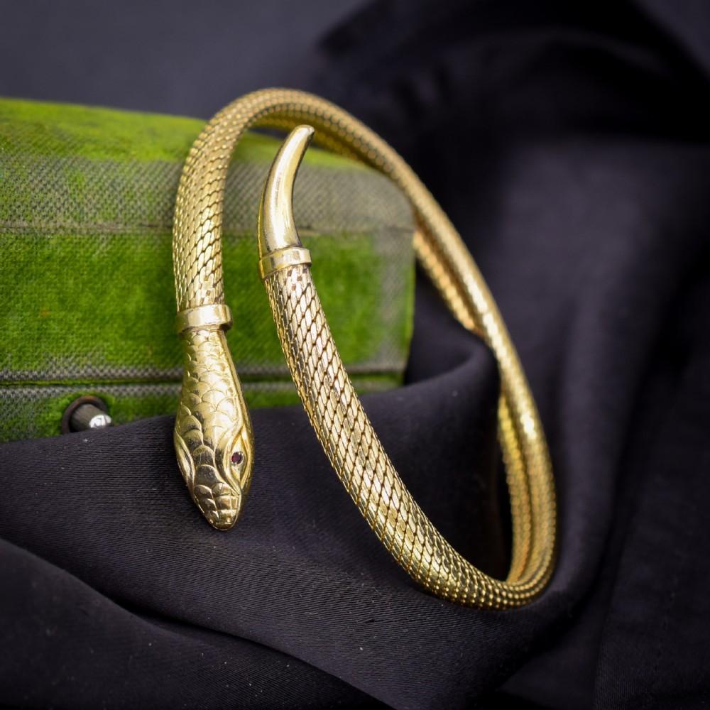 A rolled gold coiled snake bangle bracelet featuring detailed scale engraving, a sculpted head, and a tapered tail. View III