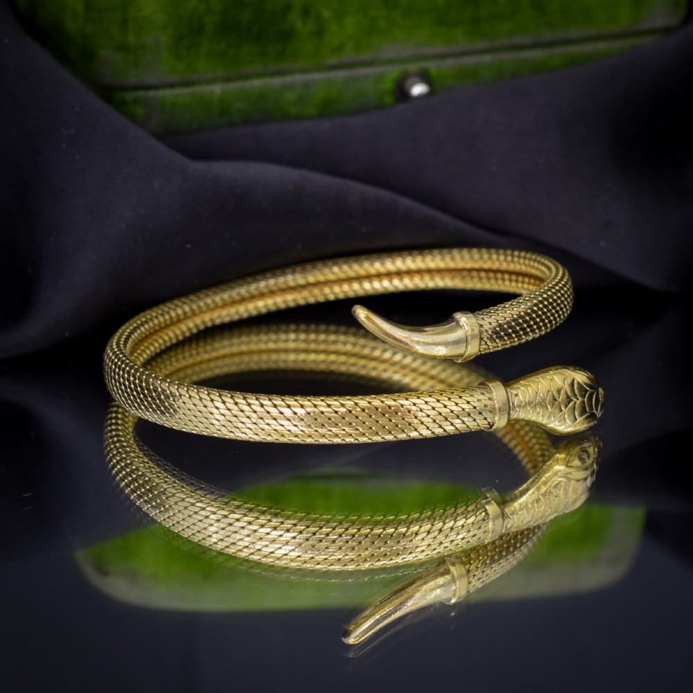 A rolled gold coiled snake bangle bracelet featuring detailed scale engraving, a sculpted head, and a tapered tail. View V