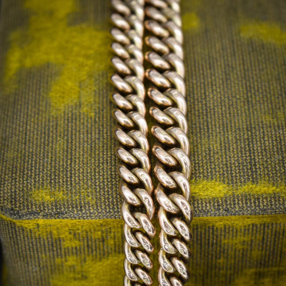 An antique 9ct gold graduated curb link Albert watch chain featuring a central T-bar and twin swivel dog clips. View V