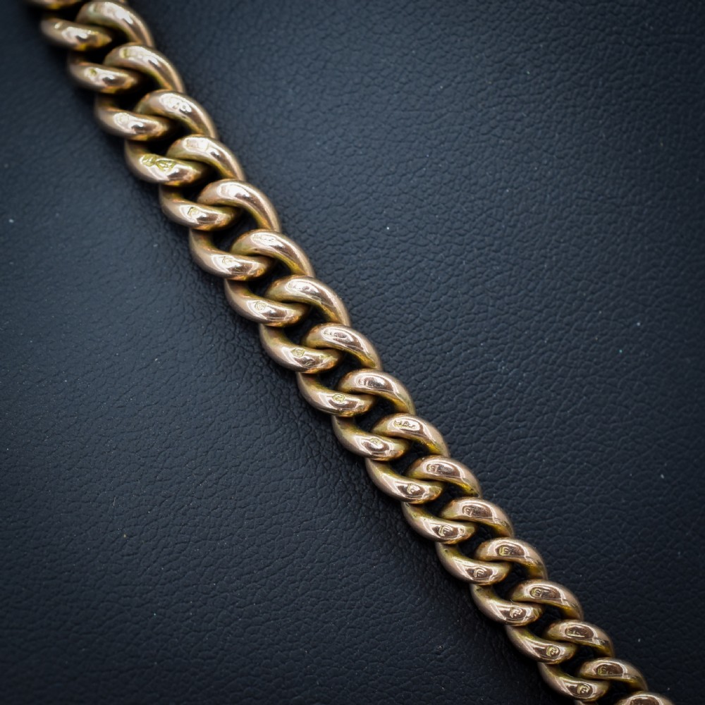 An antique 9ct gold graduated curb link Albert watch chain featuring a central T-bar and twin swivel dog clips. View VIII