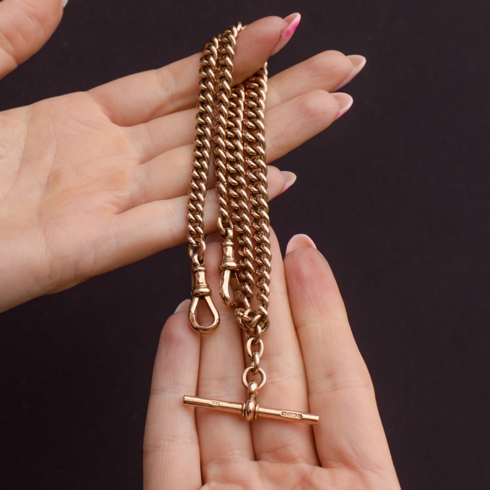 An antique 9ct gold graduated curb link Albert watch chain featuring a central T-bar and twin swivel dog clips. View X