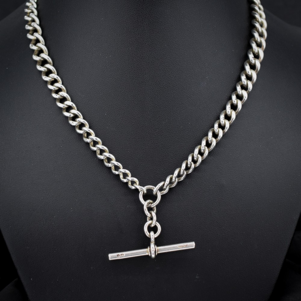 An antique sterling silver curb link watch chain featuring a classic T-bar pendant.