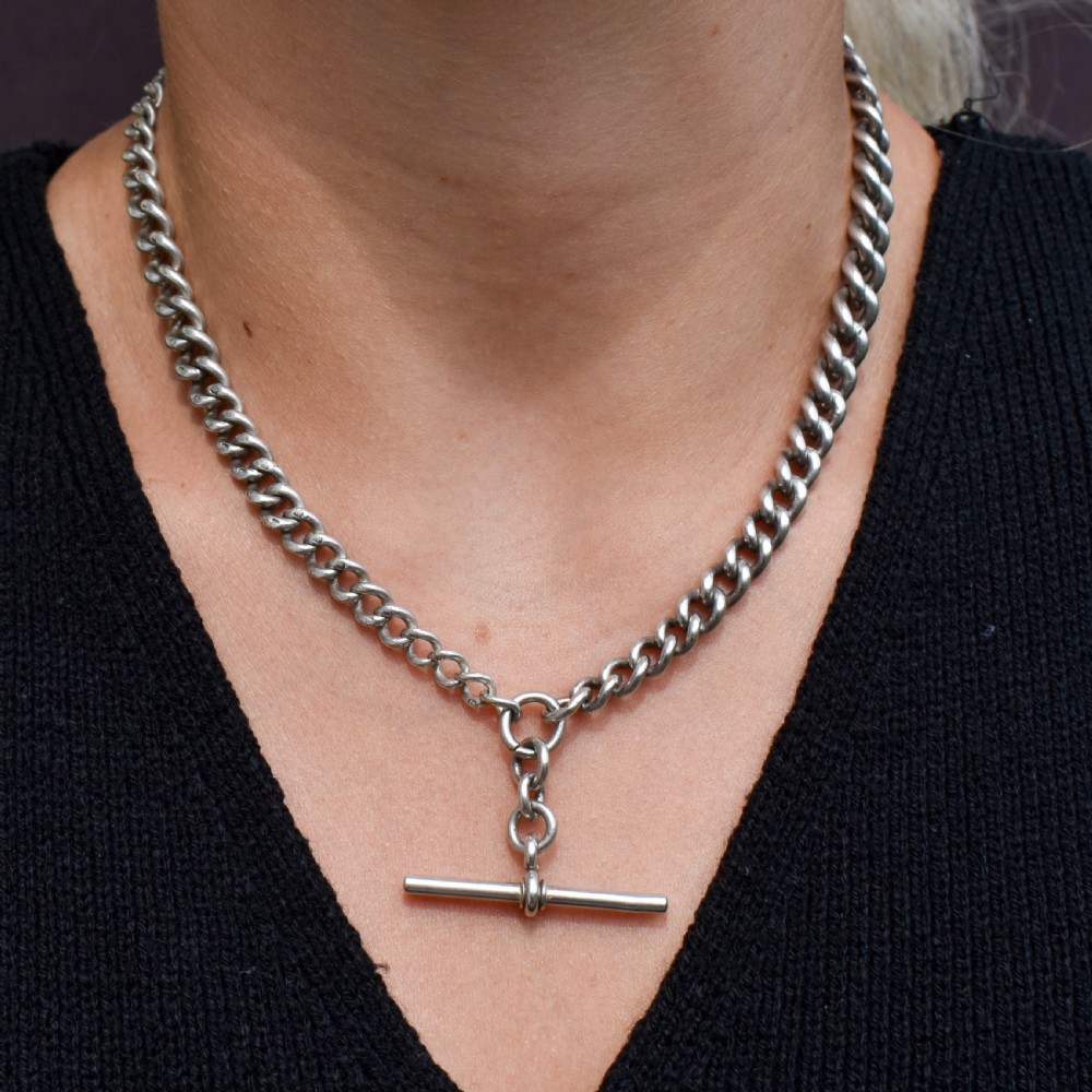 An antique sterling silver curb link watch chain featuring a classic T-bar pendant. View IX