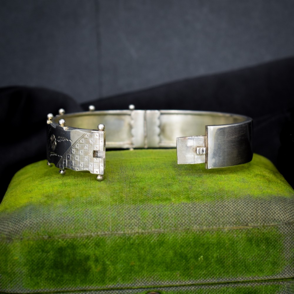 A wide silver hinged cuff bangle featuring engraved floral foliage and applied gold bird motifs along the outer band. View IV