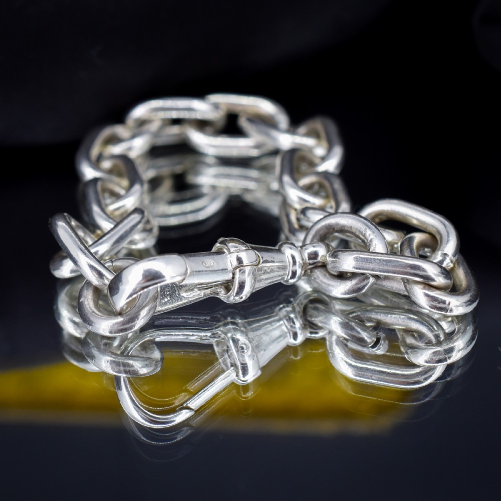 A chunky sterling silver link bracelet with polished oval links secured by a swivel dog clip clasp. View VI