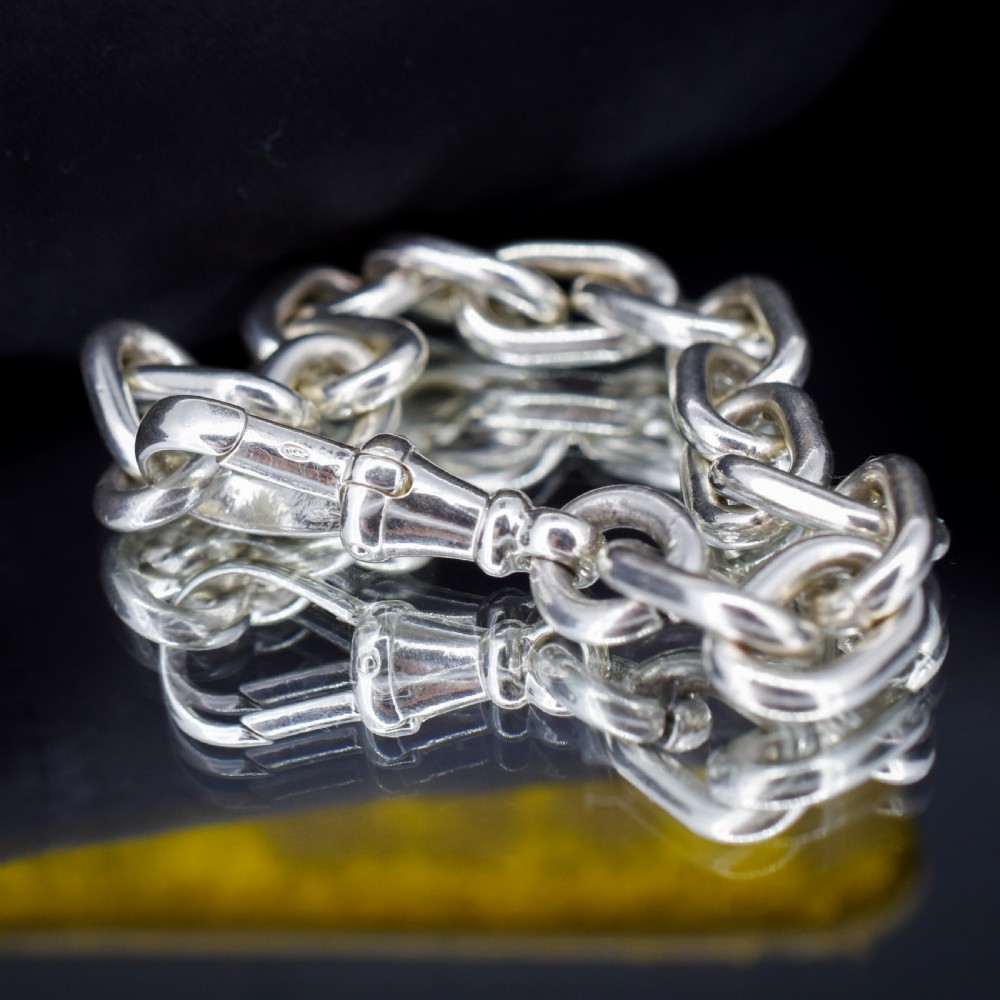 A chunky sterling silver link bracelet with polished oval links secured by a swivel dog clip clasp. View VII