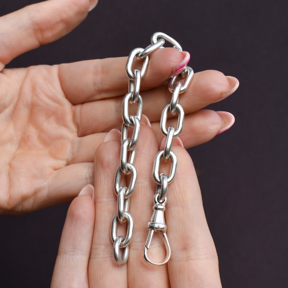 A chunky sterling silver link bracelet with polished oval links secured by a swivel dog clip clasp. View VIII