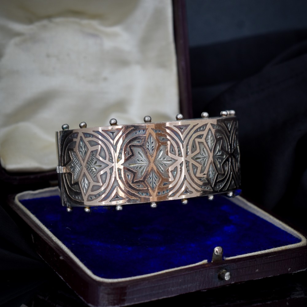 An antique Victorian wide hinged silver bangle decorated with hand-engraved geometric star motifs and a beaded upper and lower rim. View III