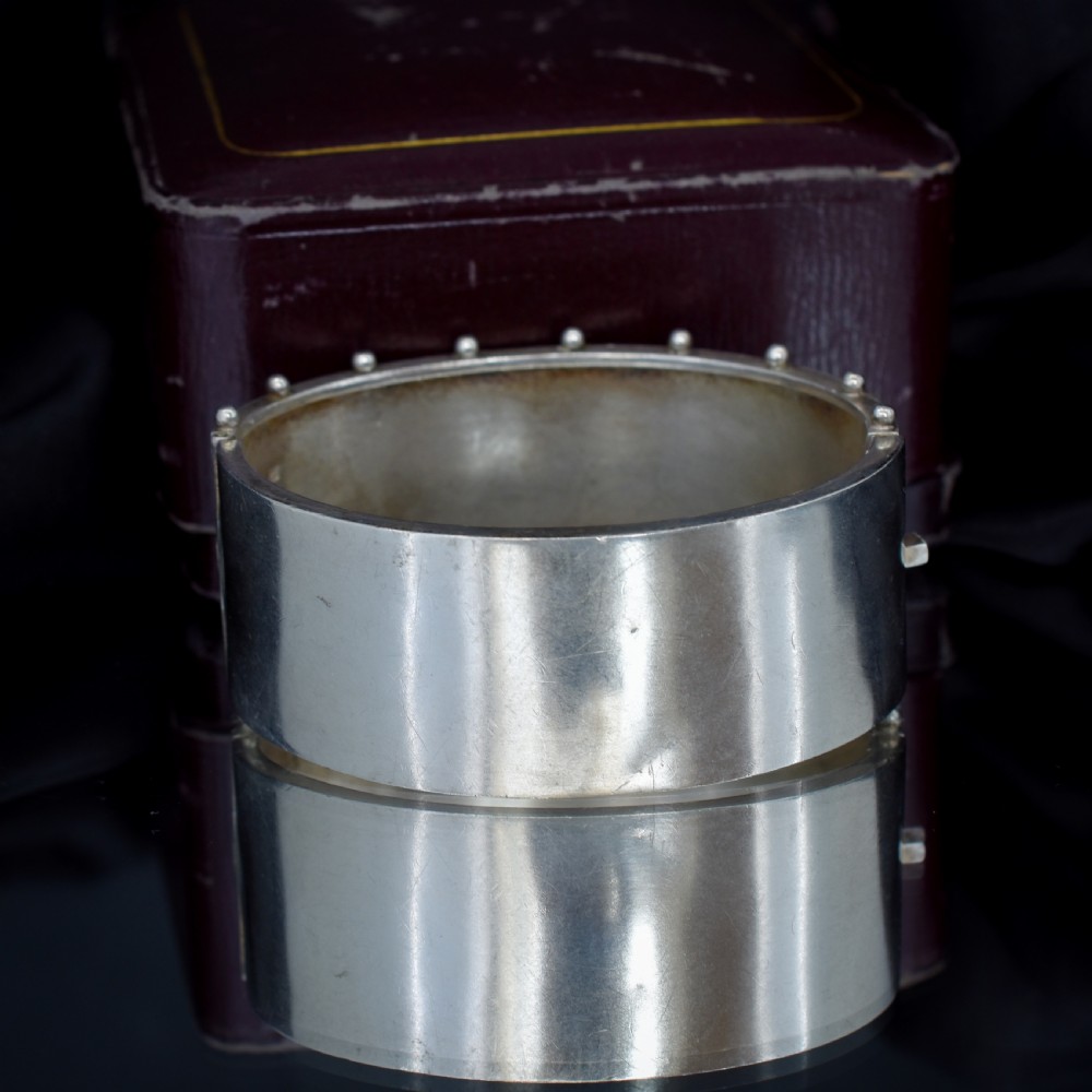 An antique Victorian wide hinged silver bangle decorated with hand-engraved geometric star motifs and a beaded upper and lower rim. View V
