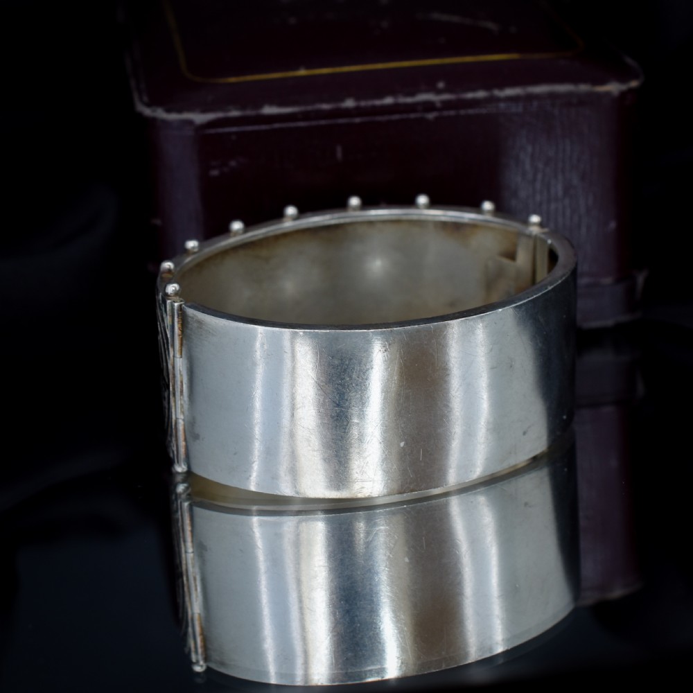 An antique Victorian wide hinged silver bangle decorated with hand-engraved geometric star motifs and a beaded upper and lower rim. View VI