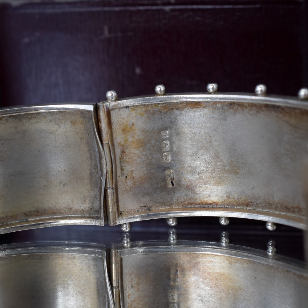 An antique Victorian wide hinged silver bangle decorated with hand-engraved geometric star motifs and a beaded upper and lower rim. View VIII