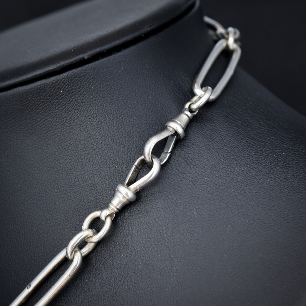 An antique Victorian sterling silver pocket watch chain featuring elongated trombone links, twisted love knot details, a T-bar, and a swivel clip. View VIII