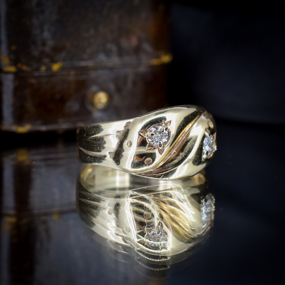 A yellow gold band featuring two entwined snake heads, each set with a star-engraved diamond. View VI
