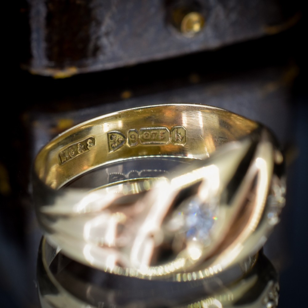 A yellow gold band featuring two entwined snake heads, each set with a star-engraved diamond. View VII