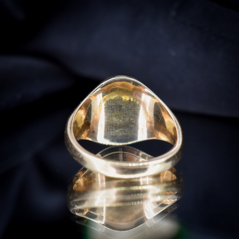 A vintage 9ct yellow gold signet ring featuring an oval bezel hand-engraved with a crest intaglio design. View VI