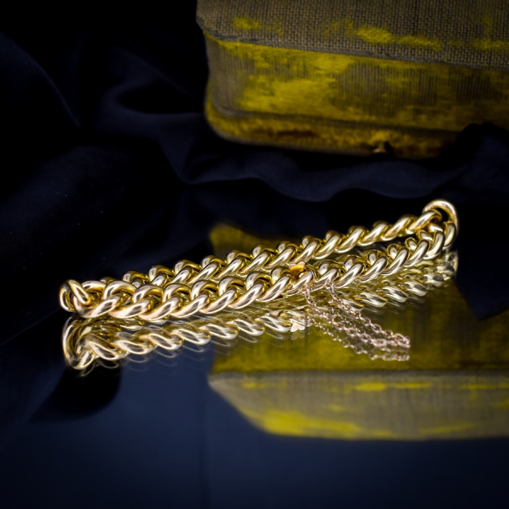 An 18ct yellow gold curb link bracelet featuring a concealed box clasp and an attached safety chain. View II