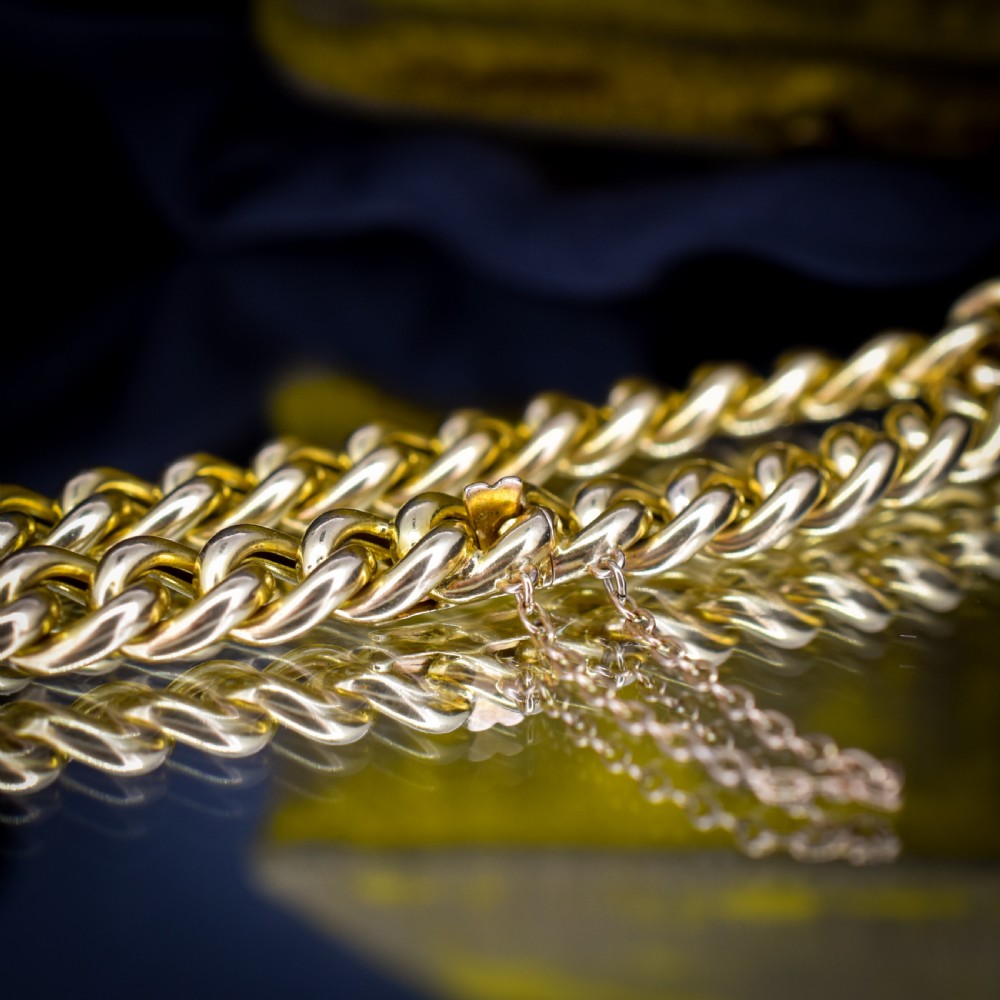 An 18ct yellow gold curb link bracelet featuring a concealed box clasp and an attached safety chain. View III