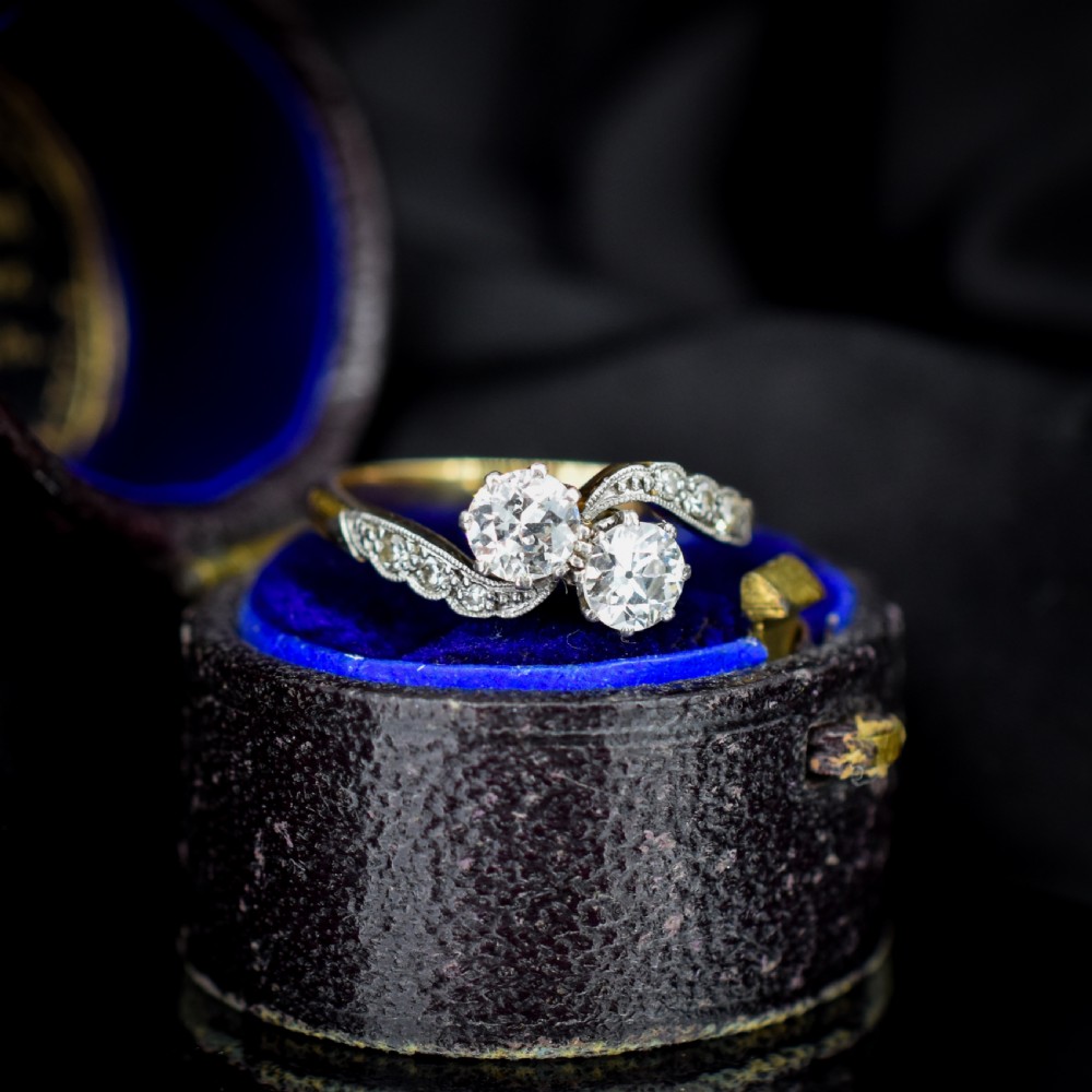 An antique diamond Toi et Moi ring featuring two diamonds set in a platinum crossover mount on an eighteen carat gold band. View II