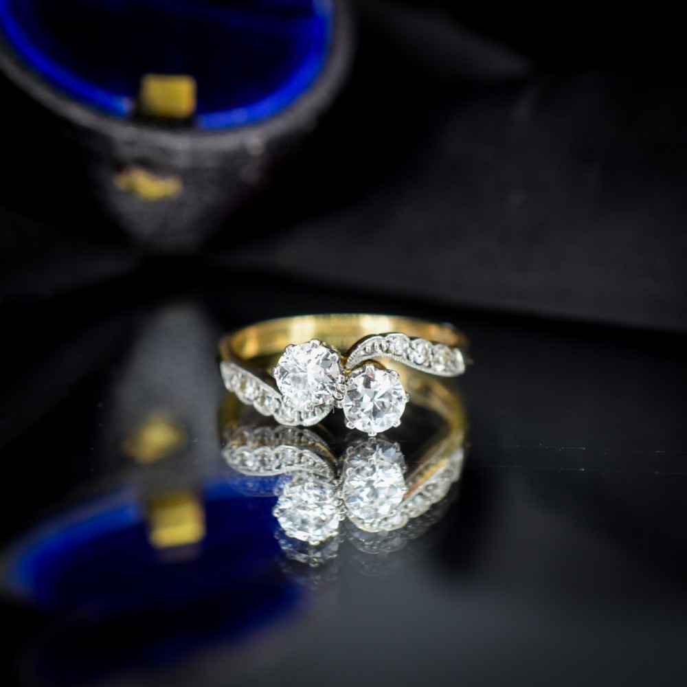 An antique diamond Toi et Moi ring featuring two diamonds set in a platinum crossover mount on an eighteen carat gold band. View IV