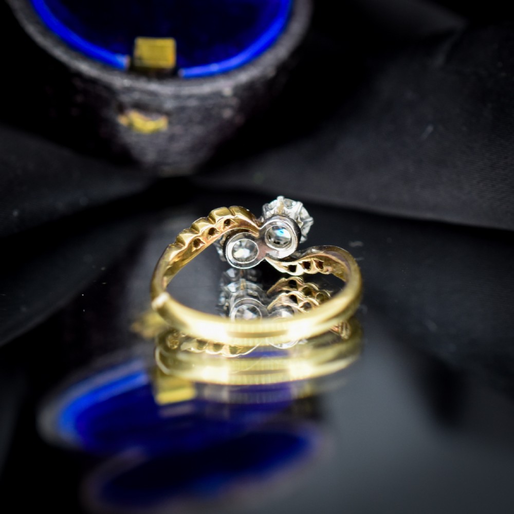 An antique diamond Toi et Moi ring featuring two diamonds set in a platinum crossover mount on an eighteen carat gold band. View VI